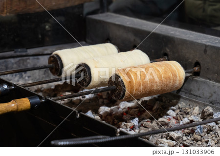 trdelnik is cooked on a fire on a special wooden dish, a traditional dessert of europe trdelnik is cooked on a fire on a special wooden dish, a traditional dessert of europe 131033906