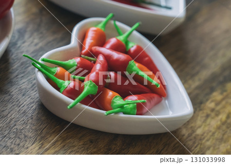 heart shaped plate wa fresh chili pepper hot close up 131033998