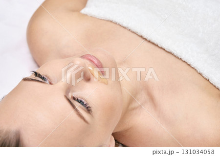Caucasian adult female undergoing facial hair removal with wax treatment in spa Caucasian adult female undergoing facial hair removal with wax treatment in spa 131034058