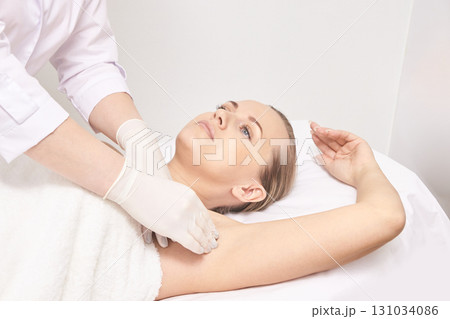 Female caucasian adult receiving underarm injection by gloved professional Female caucasian adult receiving underarm injection by gloved professional 131034086
