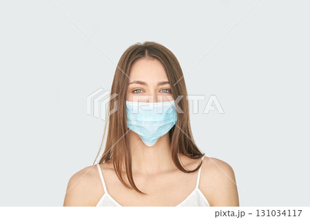 Young caucasian female wearing blue face mask for health protection against Young caucasian female wearing blue face mask for health protection against 131034117