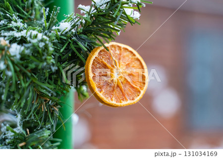 dry orange decor christmas hanging on a tree branch close-up 131034169