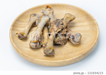 Chicken bone leftover wooden plate white background food waste cooked closeup horizontal unhealthy greasy messy 131034215