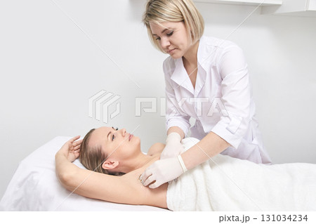 Female caucasian adult receiving professional underarm cosmetic treatment 131034234