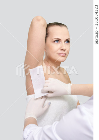 Caucasian female adult receiving underarm waxing treatment by professional Caucasian female adult receiving underarm waxing treatment by professional 131034323