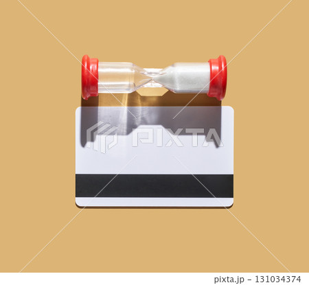 Time concept with hourglass above blank card on beige background representing 131034374