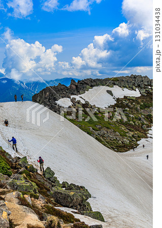 雪原を歩む登山者と雄大な空の景色 131034438