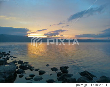夕焼けに染まる湖と雲の彩り 131034501