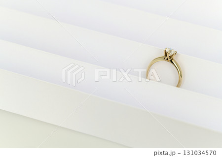 A gold ring with a diamond is on a white background A gold ring with a diamond is on a white background 131034570