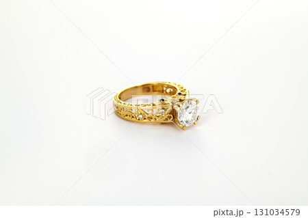 A gold and white ring with a large diamond in the center 131034579