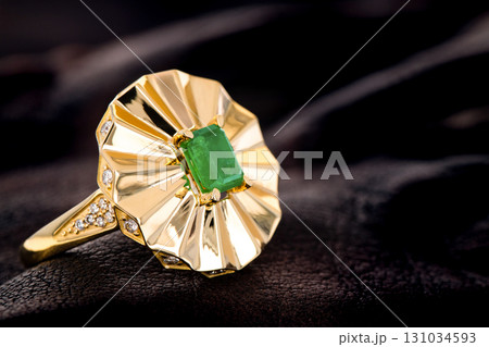 A gold and green emerald gemstone ring with diamonds A gold and green emerald gemstone ring with diamonds 131034593
