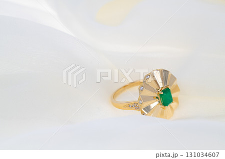 A gold emerald ring with a diamond in the center A gold emerald ring with a diamond in the center 131034607