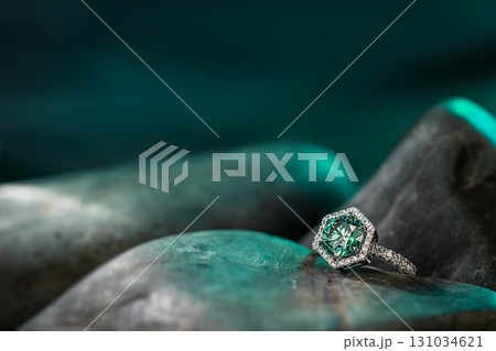 A green stone with a diamond on top of it 131034621
