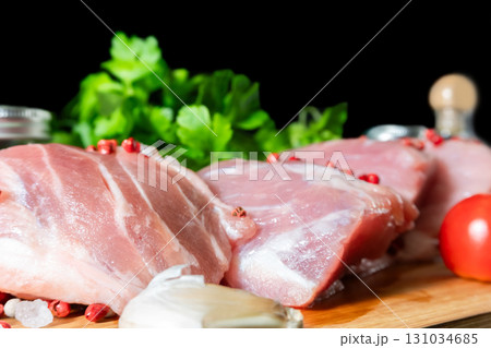 Raw Meat with Tomatoes Garlic and Parsley on Cutting Board 131034685