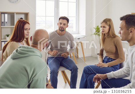 Adult men and women are discussing their problems during a group therapy session 131036255