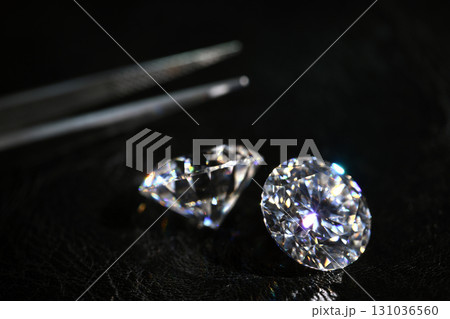 Two diamonds are on a black surface 131036560