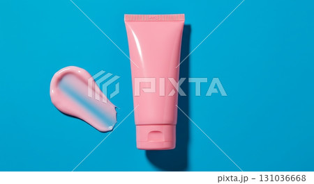 Vibrant pink cosmetic cream tube with swatch on bright blue background, perfect for beauty ads. 131036668