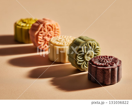 Colorful mooncakes on beige background casting shadows Colorful mooncakes on beige background casting shadows 131036822