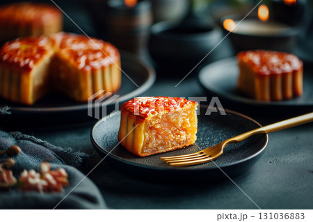 slice of mooncake on black plate with golden fork 131036883