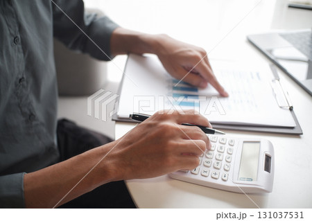 Closeup hand of  businessman using calculator, laptop and reading report in office 131037531