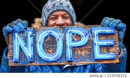 Smiling individual holding a wooden sign with bright blue letters spelling out a playful message 131038313
