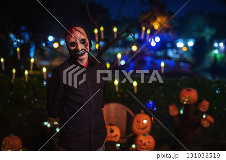 Spooky man with devil mask stand by pumpkin and candle, Halloween 131038519