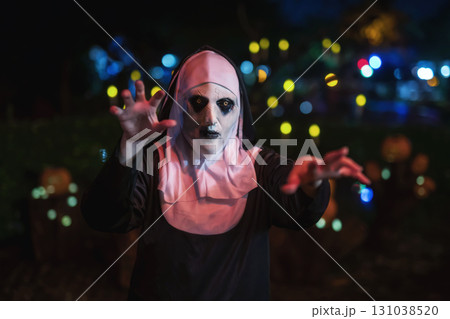 Spooky female devilish nun with fear hand gesture at night. 2025 Halloween 131038520