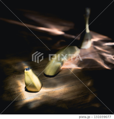 Yellow fresh banana on a black background in the rays of sun. Yellow fresh banana on a black background in the rays of sun. 131039077