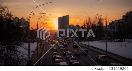 The view of the beautiful sunset on the road with cars in the city. The view of the beautiful sunset on the road with cars in the city. 131039262