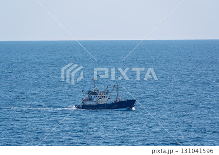 Fishing boat in blue sea and clear sky with birds flying overhead. Fishing boat in blue sea and clear sky with birds flying overhead. 131041596