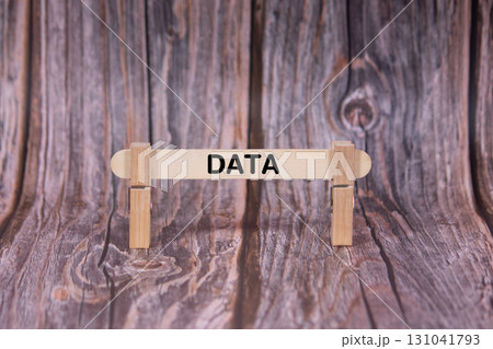 Data symbol. A wooden stick clasped by clothespins set over a beautiful Brown Grunge Wooden Texture Background. Business and Data concept with copy space 131041793