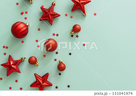 Red Christmas Ornaments and Confetti on Light Blue Background Red Christmas Ornaments and Confetti on Light Blue Background 131041974
