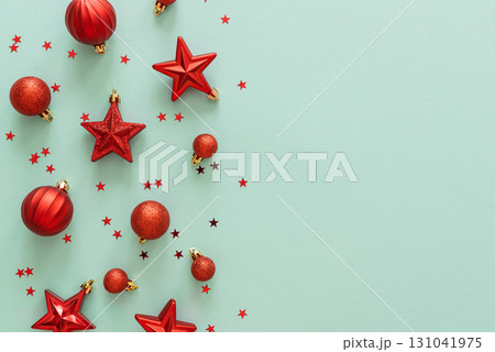 Red Christmas Ornaments and Confetti on Light Blue Background 131041975
