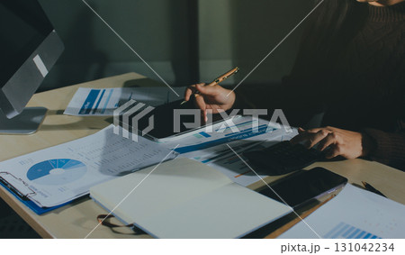 Close-up of businessman's hands making notes, mobiles, chart, desk, office 131042234