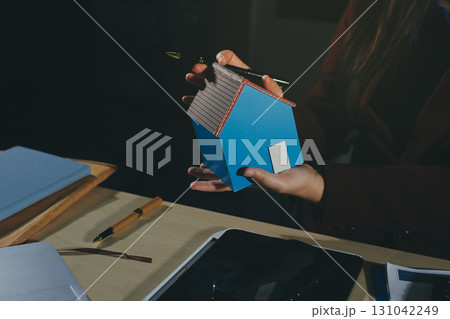 Customer signing a real estate contract in real estate agency. Customer signing a real estate contract in real estate agency. 131042249
