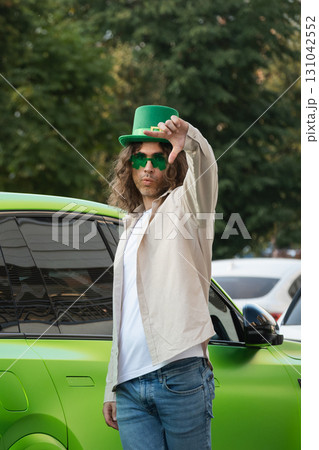 Happy Man Wearing Shamrock clover glasses and Green St. Patrick's Hat enjoy at urban city at street. Outdoors. Space for design. 131042552