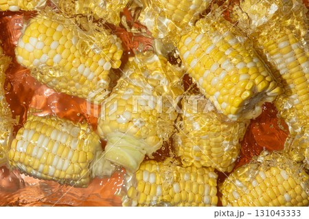 Fresh corn cobs splashing in water top view. Fresh corn cobs splashing in water top view. 131043333