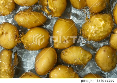 Whole Organic Raw Potatoes In Water Top View, Splash And Ripples. Whole Organic Raw Potatoes In Water Top View, Splash And Ripples. 131043335
