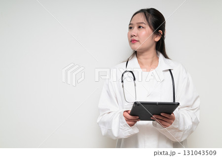Portrait of young Asian healthcare worker woman doctor in lab coat using digital tablet computer Portrait of young Asian healthcare worker woman doctor in lab coat using digital tablet computer 131043509