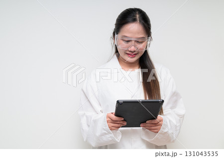 Asian healthcare worker scientist woman in lab coat using digital tablet computer Asian healthcare worker scientist woman in lab coat using digital tablet computer 131043535