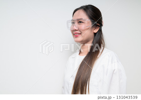 Profile view of Asian healthcare worker scientist woman in lab coat wearing safety goggle glasses Profile view of Asian healthcare worker scientist woman in lab coat wearing safety goggle glasses 131043539