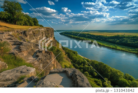 Serene River View With Cliffs and Lush Greenery Under a Bright Blue Sky 131043842
