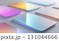 Glowing smartphones with color gradients resting on minimalist white surface, demonstrating wireless charging and cutting-edge mobile technology design 131044666