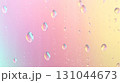 Gradient background blending soft pink and warm yellow, water droplets cascading smoothly across glossy surface, forming elegant abstract visual pattern 131044673