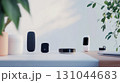 Smart speaker, tracker, hub, watch, and wireless earbuds are displayed on white desk, showcasing connected home technology enhancing modern living 131044683