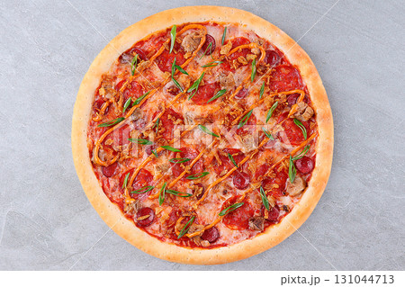 Delicious Meat Pizza with Pepperoni, Bacon, Sausage, Green Onions, and Crispy Onions on Tomato Sauce and Melted Cheese 131044713