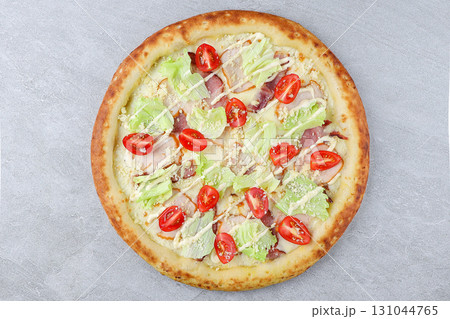 Caesar Salad Style Pizza with Bacon, Lettuce, Cherry Tomatoes, Parmesan and Creamy Dressing on Gray Stone Background 131044765