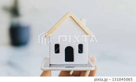 Person holding a tablet featuring a sleek modern home 131045065