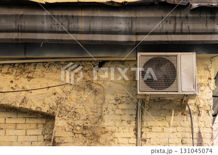 old and dusty air conditioner on the facade of a brick house. air ventilation and cooling system. 131045074