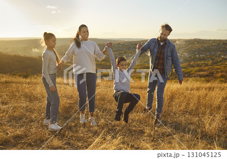 Happy smiling family with kids having fun together and walking outdoors in nature. 131045125